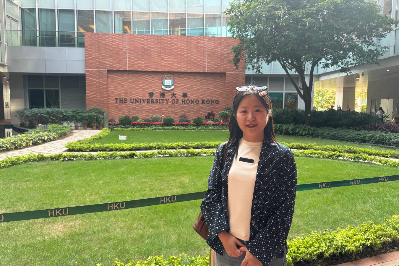 Tourist Yang Dan poses for a photo at HKU's iconic Red Wall on March 6, 2026. Photo by Huang Shixian
