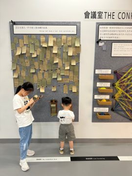 Two young visitors write their responses on the interactive message wall at the exhibition on April 11. (Photo by Huang Shixian)