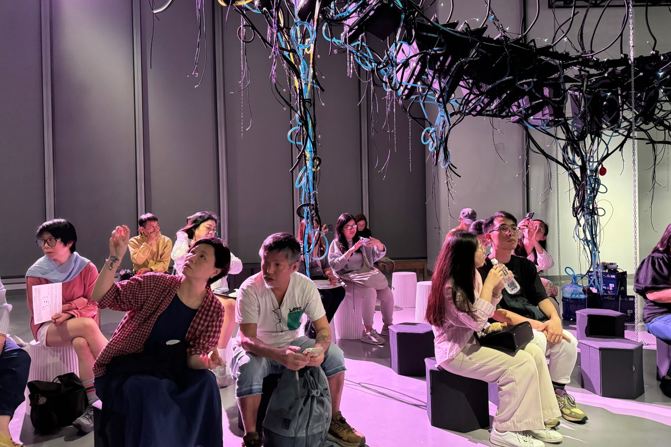 Visitors sit among the installation, immersing themselves in the artists' sharing session on April 11. (Photo by Huang Shixian)